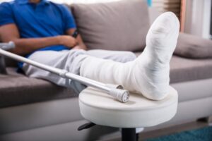 Close-up of a man's broken leg with crutches following an accident.