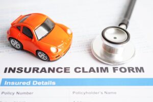 Stethoscope placed on an insurance claim form for a car accident, representing car loans, insurance, and leasing concepts.