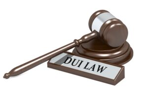 A 3D rendering of a judge's gavel resting on a wooden surface, with a banner displaying the text "DUI Law" above it. The gavel symbolizes legal authority, while the banner emphasizes the focus on driving under the influence (DUI) laws. The scene suggests a legal context related to DUI cases, highlighting the judicial process and its consequences.